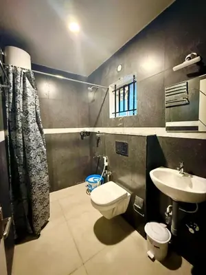 a bathroom with a toilet and a sink at Humming Bird By Brown Tree Resorts in Kotagiri
