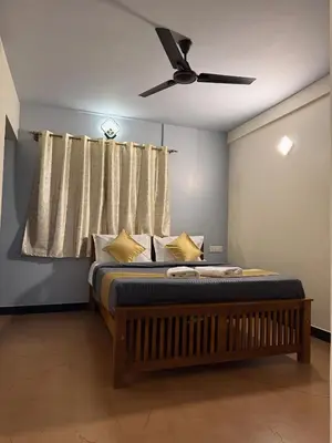 a bedroom with a bed with a ceiling fan at Humming Bird By Brown Tree Resorts in Kotagiri