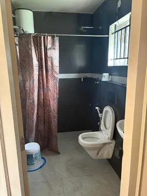 a bathroom with a toilet and a sink at Humming Bird By Brown Tree Resorts in Kotagiri