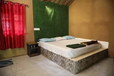 a bedroom with a large bed with red curtains at Vihara Mudcamp in Marayoor