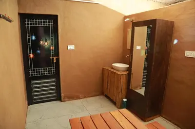 a bathroom with a toilet and a sink and a mirror at Vihara Mudcamp in Marayoor
