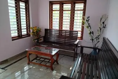 a room with a bench and a table and windows at Malayil Peacock Villa in Wayanad