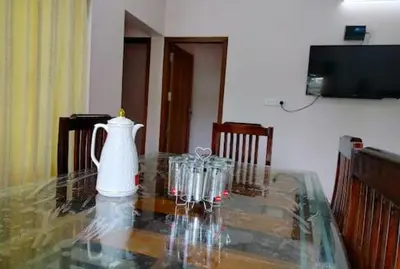 a glass table with a white vase on top of it at Malayil Peacock Villa in Wayanad