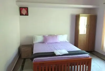 a bedroom with a bed with purple sheets and a door at Malayil Peacock Villa in Wayanad