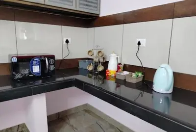 a kitchen counter with a counter top with a counter top at Malayil Peacock Villa in Wayanad