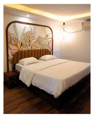 a bedroom with a large bed with a large headboard at Event House, Mysore in Mysore