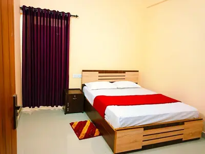 a bedroom with a bed with a red blanket at Anna rooms in Chekadi