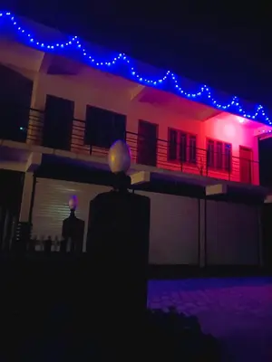 a man standing in front of a house at night at Anna rooms in Chekadi