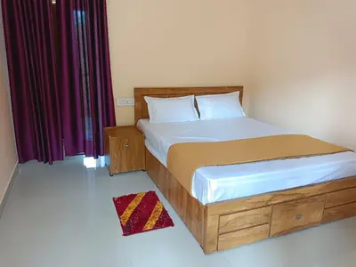 a bedroom with a bed with a wooden frame and curtains at Anna rooms in Chekadi