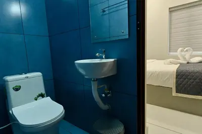 a blue bathroom with a toilet and a sink at Star Guest House