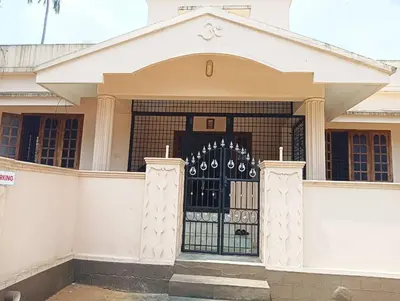 a white house with a gate in front of it at Shield Guest Accommodation in Pudunagaram