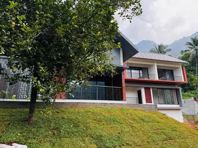 a house with a tree in front of it at GINGY Holidays in Wayanad