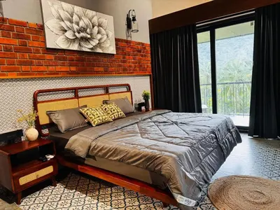 a bedroom with a bed and a brick wall at GINGY Holidays in Wayanad