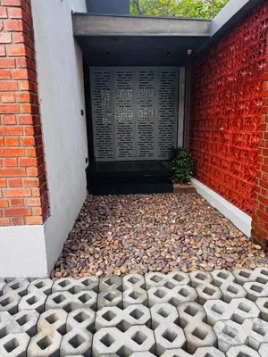 a building with a red brick wall and a door at GINGY Holidays in Wayanad