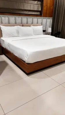 a bed with a wooden frame in a room at GINGY Holidays in Wayanad