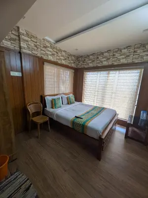 a bedroom with a large bed and a window at Ivy hostel ooty in Ooty
