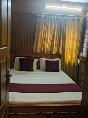 a bedroom with a large bed with curtains at Ivy hostel ooty in Ooty