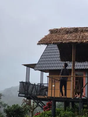 a person standing on a balcony of a hut at Mount Lux Villa in Devāla