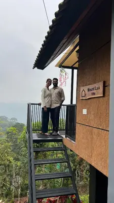 two men standing on the balcony of a mountain lodge at Mount Lux Villa in Devāla