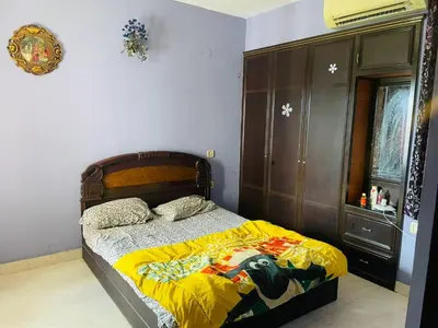 a bedroom with a bed and a wooden headboard at 2BHK Apartment in Central Thrissur in Trichūr
