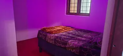 a room with a purple room with a bed in it at Dadysmud house in Kottakamboor