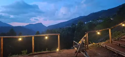 a room with a view of the mountains at night at Dadysmud house in Kottakamboor