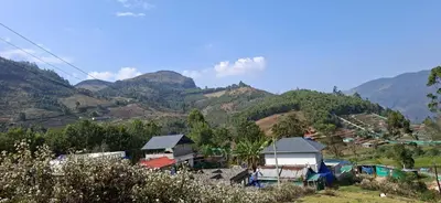 a small village with mountains in the background at Dadysmud house in Kottakamboor