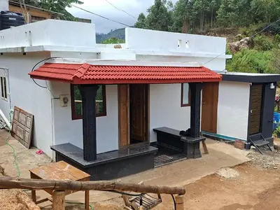 a small white house with a red roof at Dadysmud house in Kottakamboor