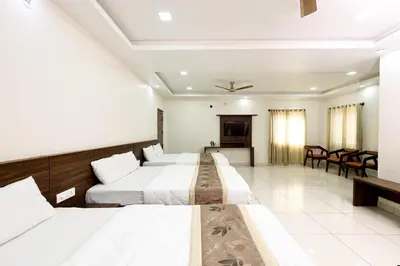 a hotel room with two beds and a television at SSR Comforts in Mandya