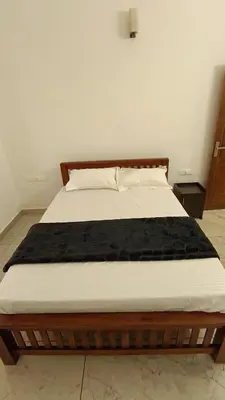 a bed in a bedroom with a wooden frame at Dolmens castle in Marayoor