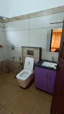a bathroom with a toilet and a sink at Dolmens castle in Marayoor