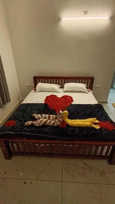 a bed with flowers and a woman on it at Dolmens castle in Marayoor