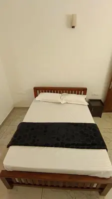 a bedroom with a bed with a black blanket on it at Dolmens castle in Marayoor
