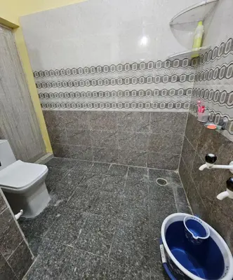 a bathroom with a toilet and a blue bowl at Suhas Nest in Mysore