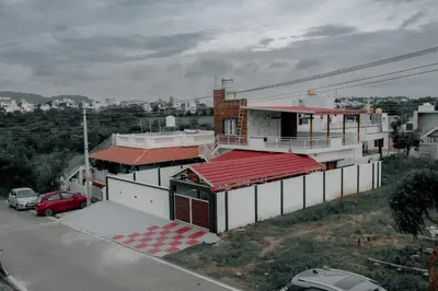 a building with a red roof on a street at Suhas Nest in Mysore