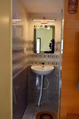 a bathroom with a sink and a mirror at Suhas Nest in Mysore
