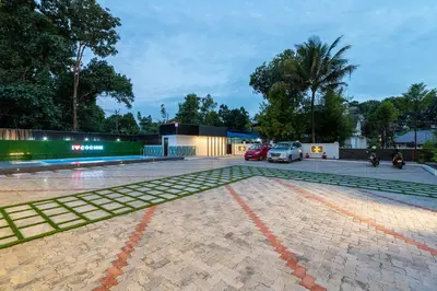a parking lot with cars parked in front of a building at Victoria Suites Airport Hotel in Nedumbassery