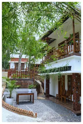 a building with a bench and a table in a courtyard at MT'S Villas in Batheri