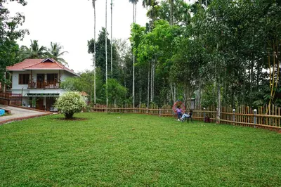 a yard with a fence and a child sitting on a swing at MT'S Villas in Batheri