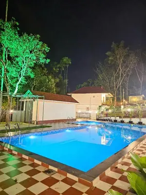 a large swimming pool with blue water at night at MT'S Villas in Batheri