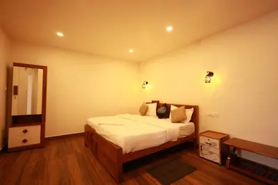 a bedroom with a bed and a dresser and a mirror at MT'S Villas in Batheri