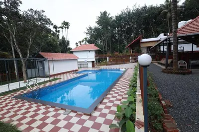 a swimming pool in front of a house at MT'S Villas in Batheri