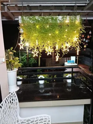 a white bench sitting in front of a table with plants at Garden view home stay for family near meitra hospital in Kozhikode