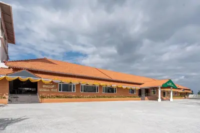 a building with an orange roof and a parking lot at Kamath Village Resortz