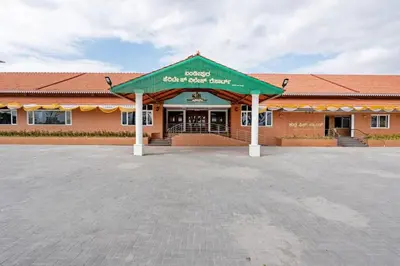 a large building with a green awning in a parking lot at Kamath Village Resortz