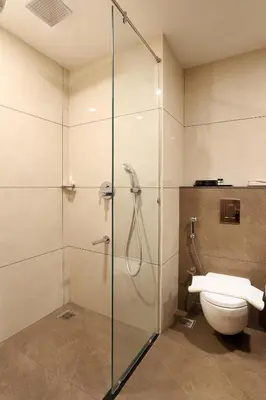 a bathroom with a glass shower with a toilet at Parays Fernwoods in Mannārakkāt