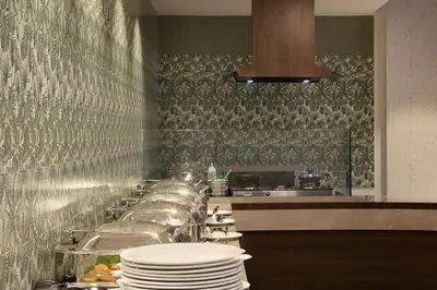 a kitchen with a long counter with plates on it at Parays Fernwoods in Mannārakkāt