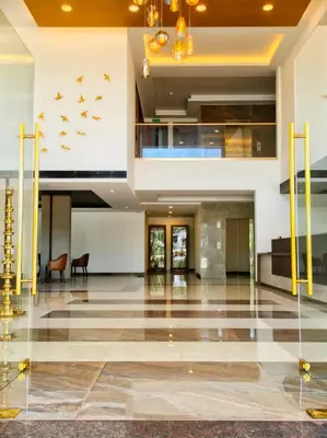 a lobby of a building with birds on the wall at Parays Fernwoods in Mannārakkāt