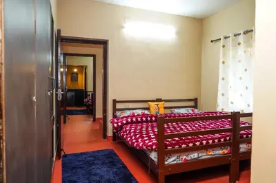 a bedroom with two beds and a hallway at Hertz home in Ooty