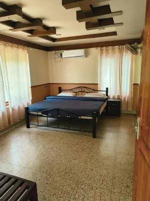 a bedroom with a bed in a room with windows at Perch by the sea 2 in Kannur